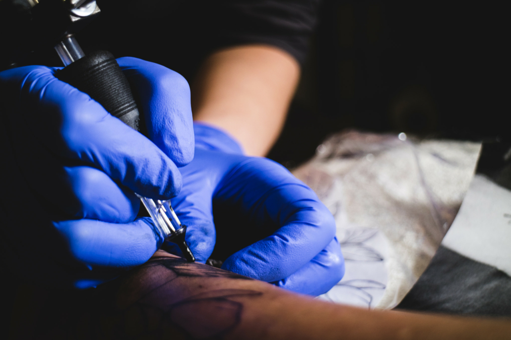 Tattoo artist working on a tattoo machine in a tattoo studio. AI Generative  30550228 Stock Photo at Vecteezy