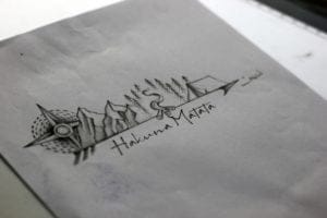 Travel tattoo to represent stories of places traveled and dreams of the bucket list that lists all the places that are in the bucket list. With a Compass to navigate the path as you move forward, Mountains and Forest for the sense of freedom with the thrill of trekking. Bonfire and a Tent to show the love for a night under the stars and the quote ‘Hakuna Matata’ to live a worry-free life sums up the tattoo story perfectly.